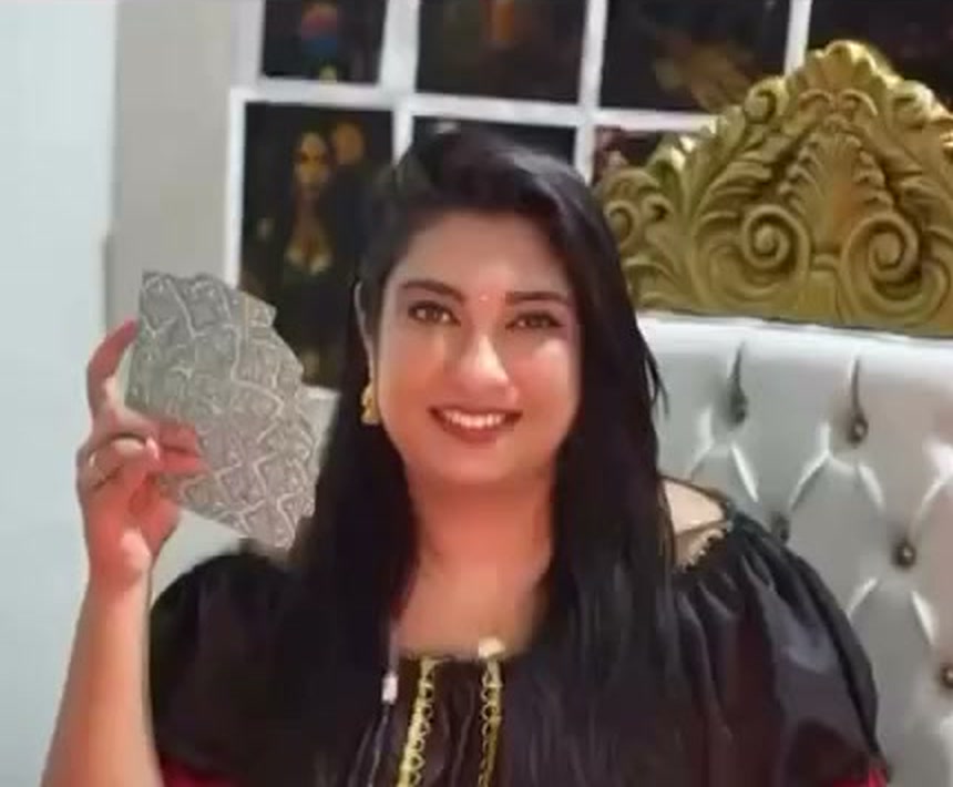 Yasmin da Cigana sorrindo e segurando cartas durante um atendimento